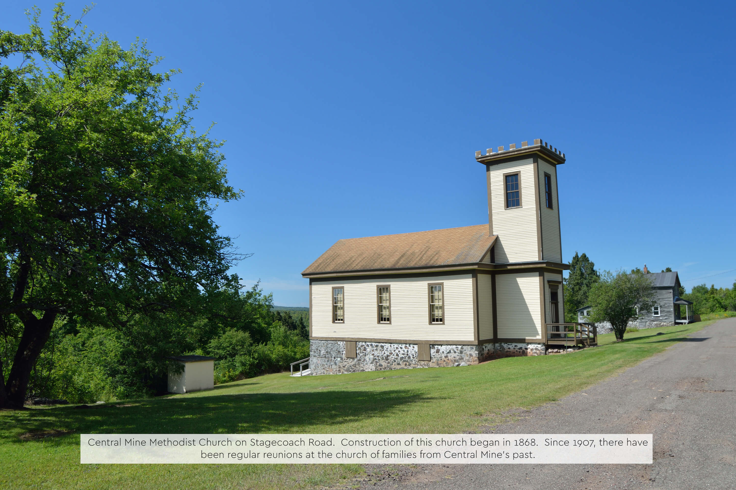 A historic white wooden church with a square tower.