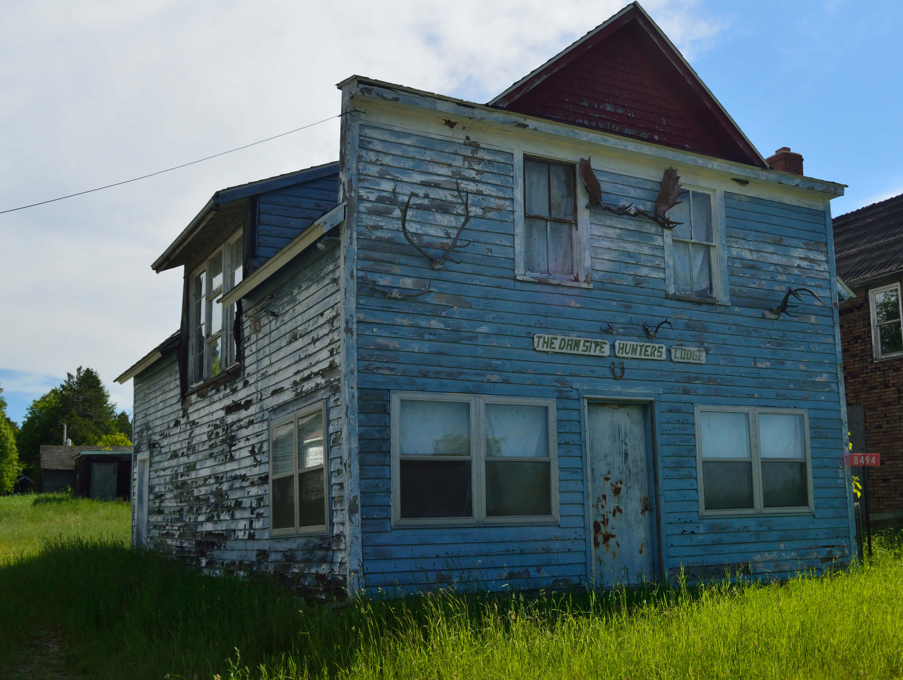 Abandoned building, The Dam Site Hunters Lodge, with peeling blue paint.