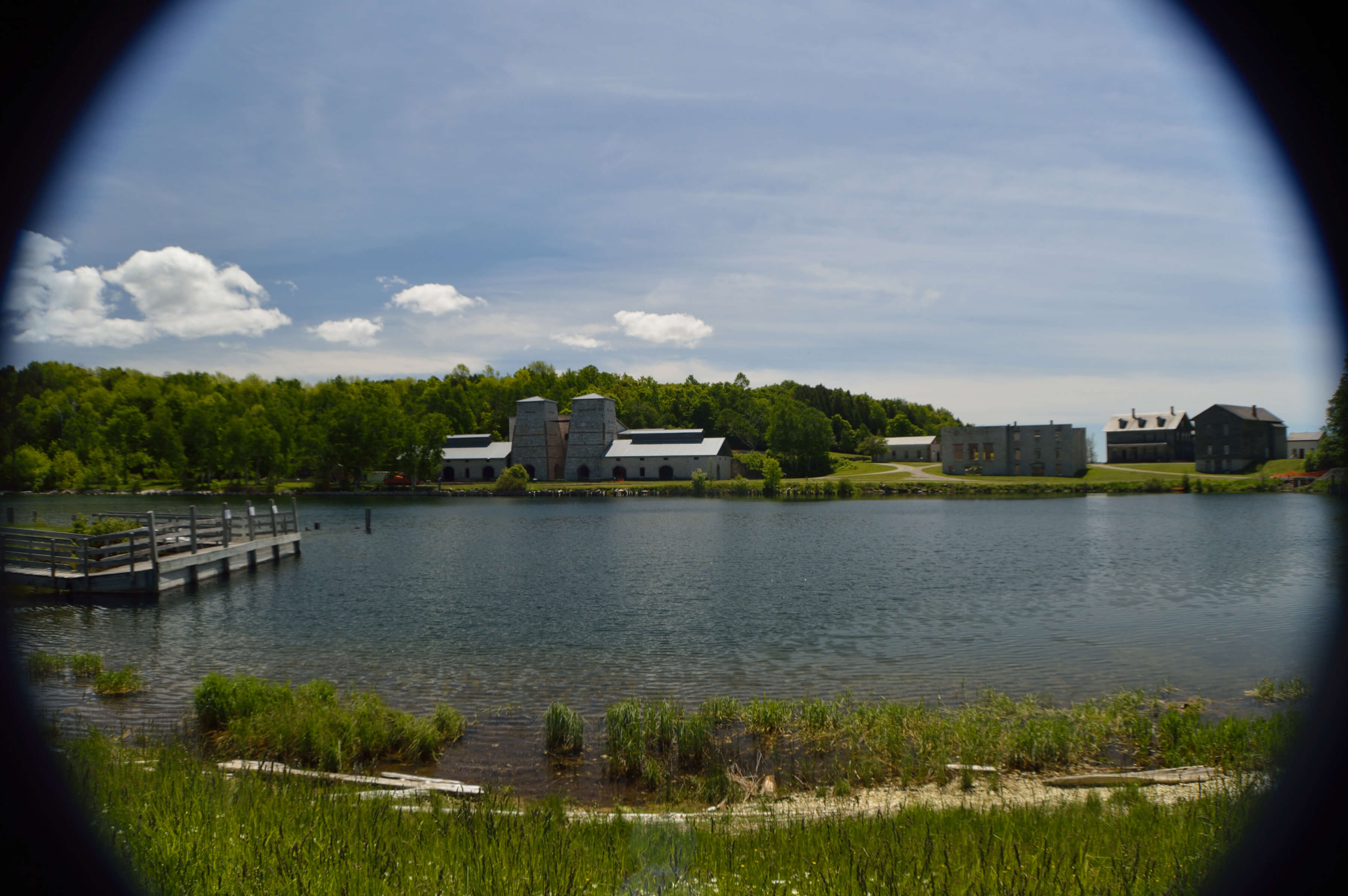 View of historic limestone buildings across Snail Shell Harbor in Fayette State Park.