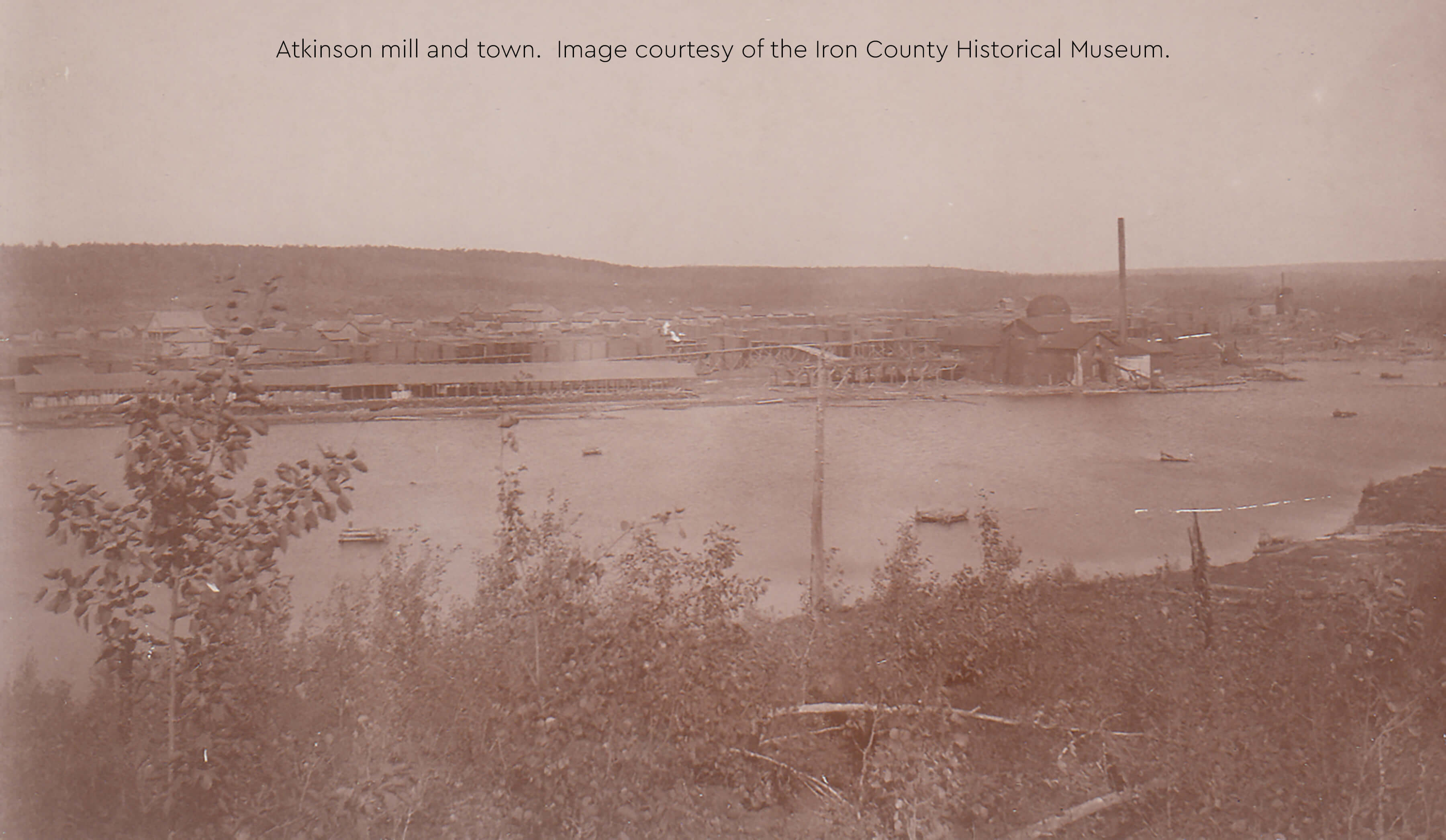 A historical photograph of Atkinson mill and town, showing industrial buildings.