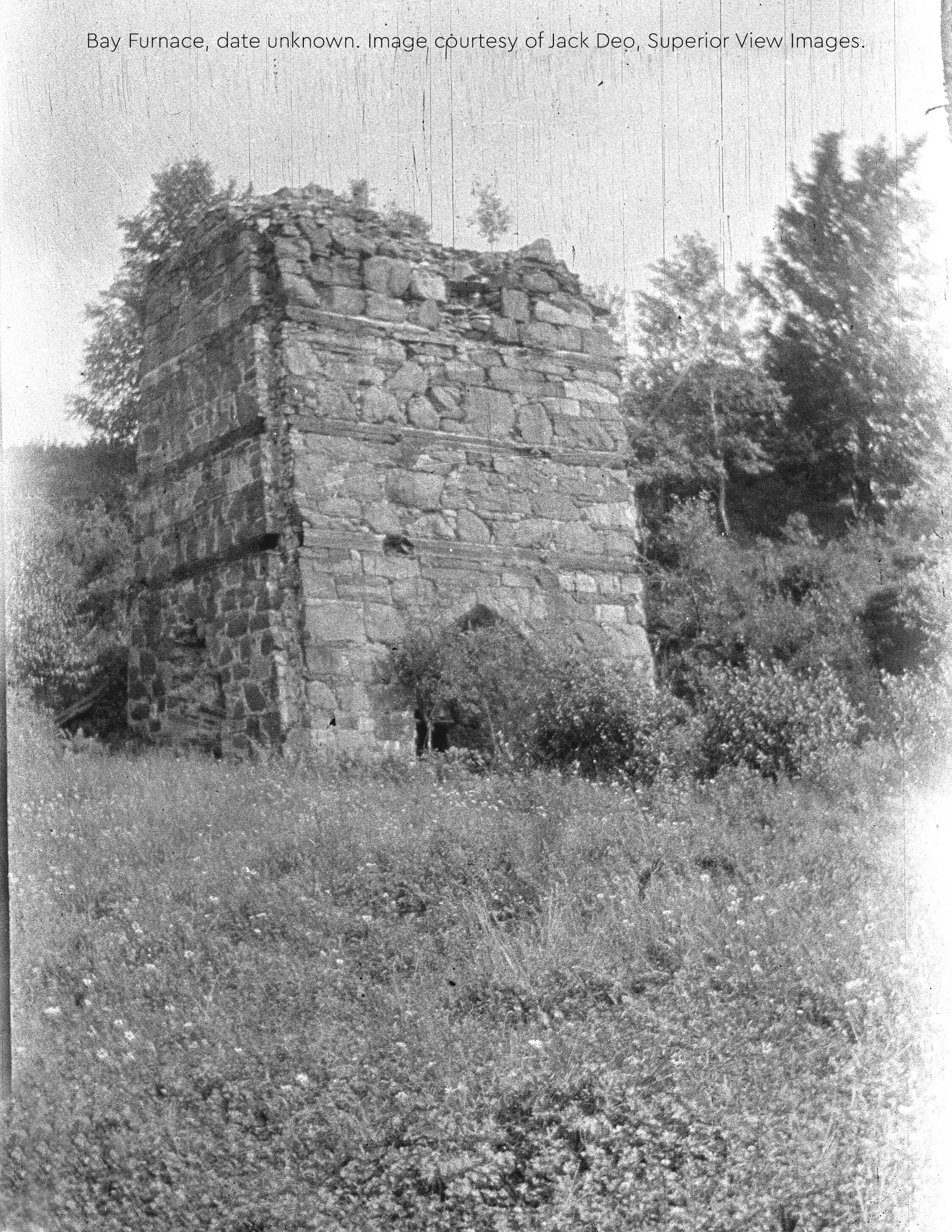 Historic Bay Furnace ruins surrounded by grass.
