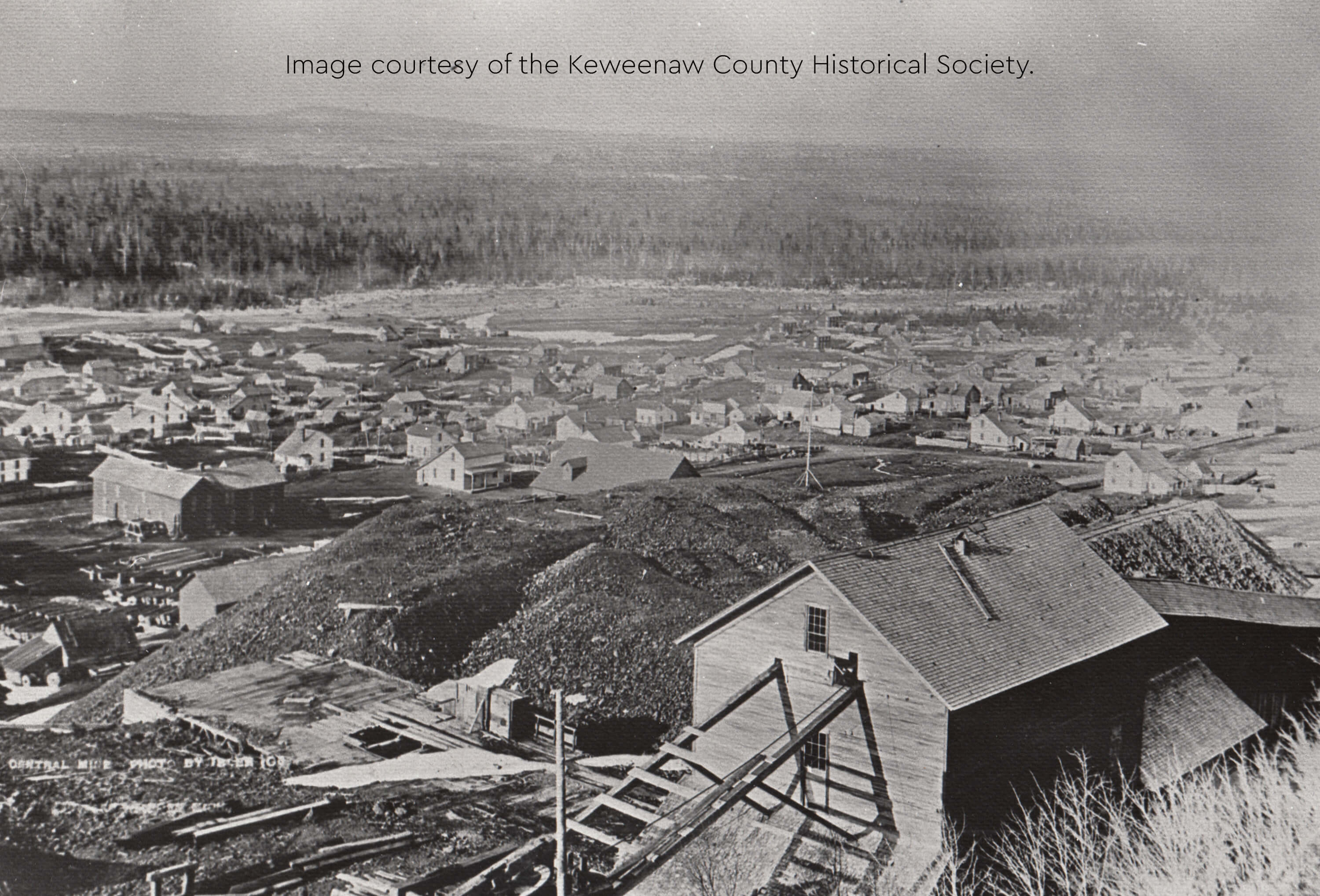A historic photo showing Central Mine with mining buildings, houses, and piles of excavation debris.