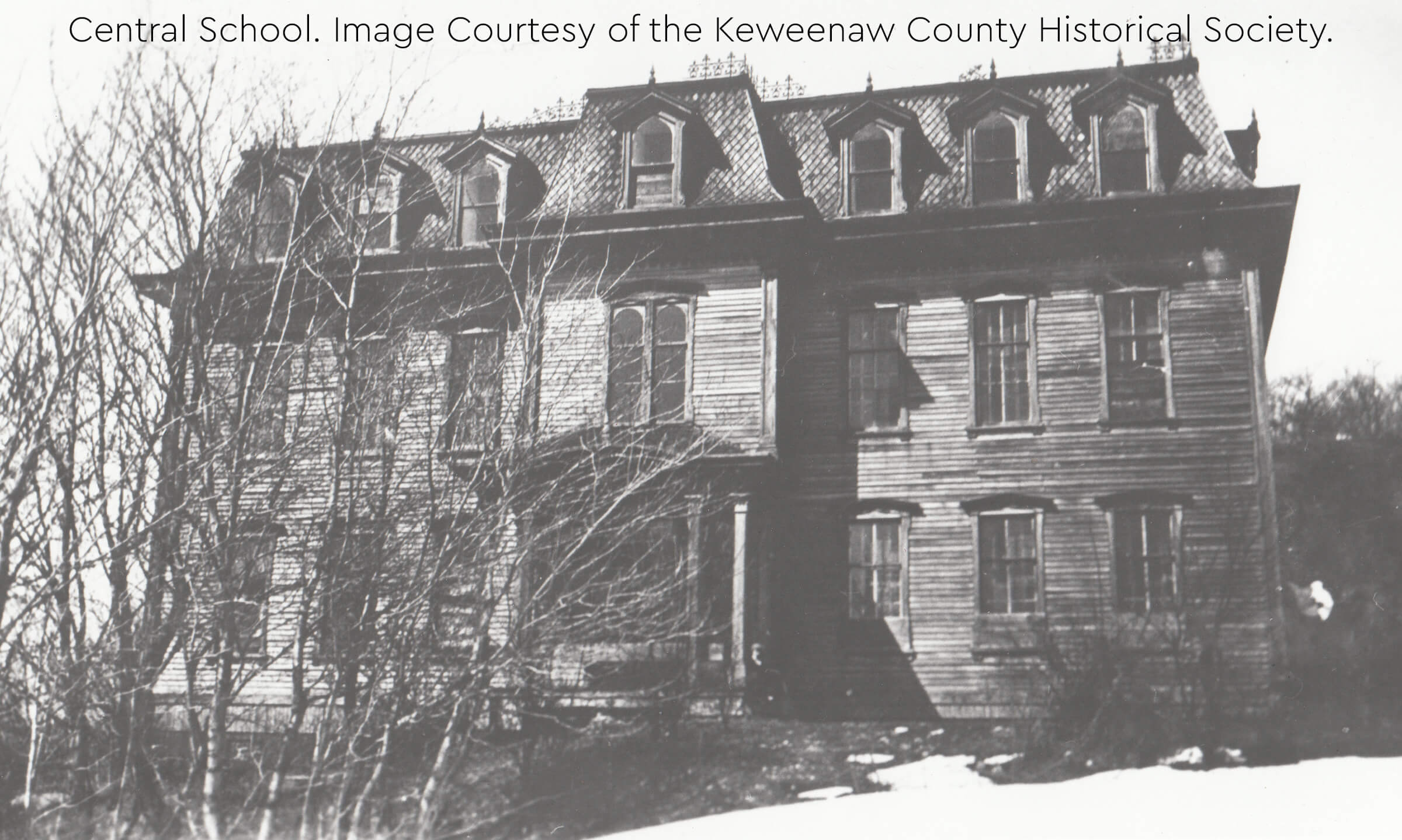Central School, a large wooden building with a mansard roof and dormer windows.