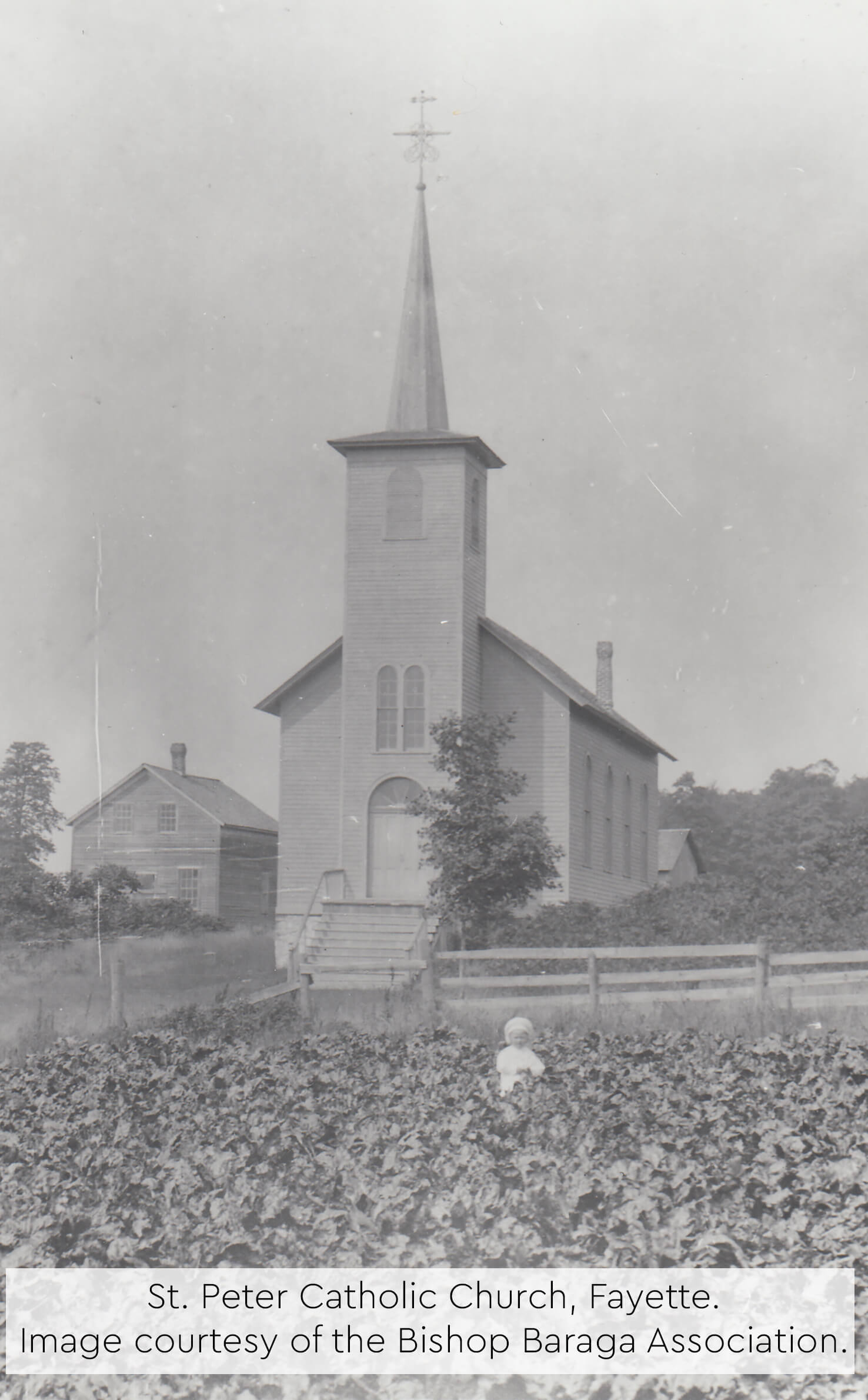 Historic photo of St. Peter Catholic Church with a child in a field.