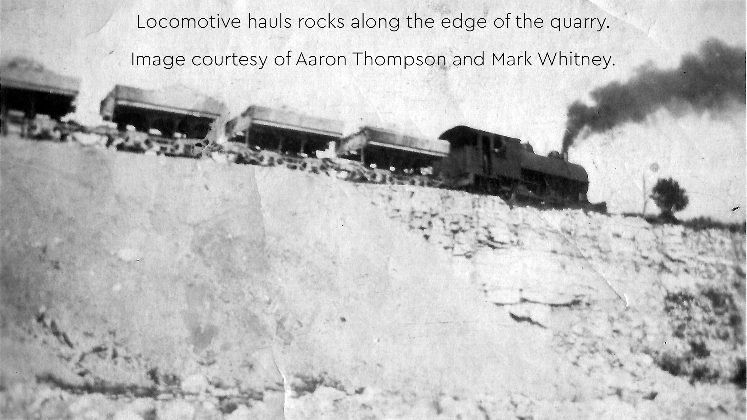 Historic photo of a locomotive hauling rock-filled cars at Fiborn Quarry.