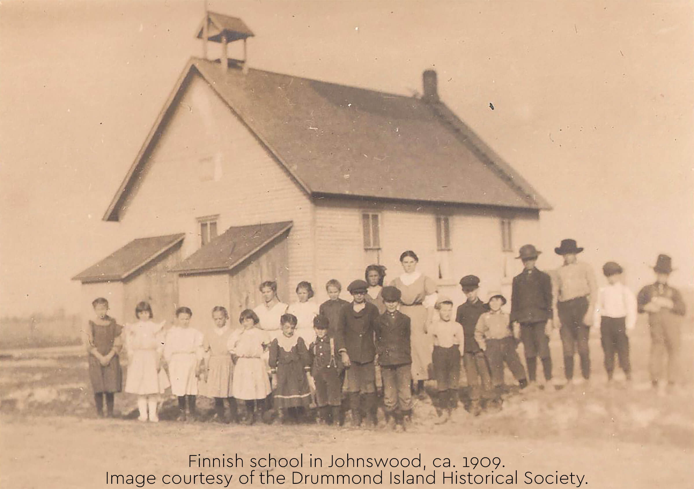 Historic photo of the Finnish school in Johnswood with children and adults in front.