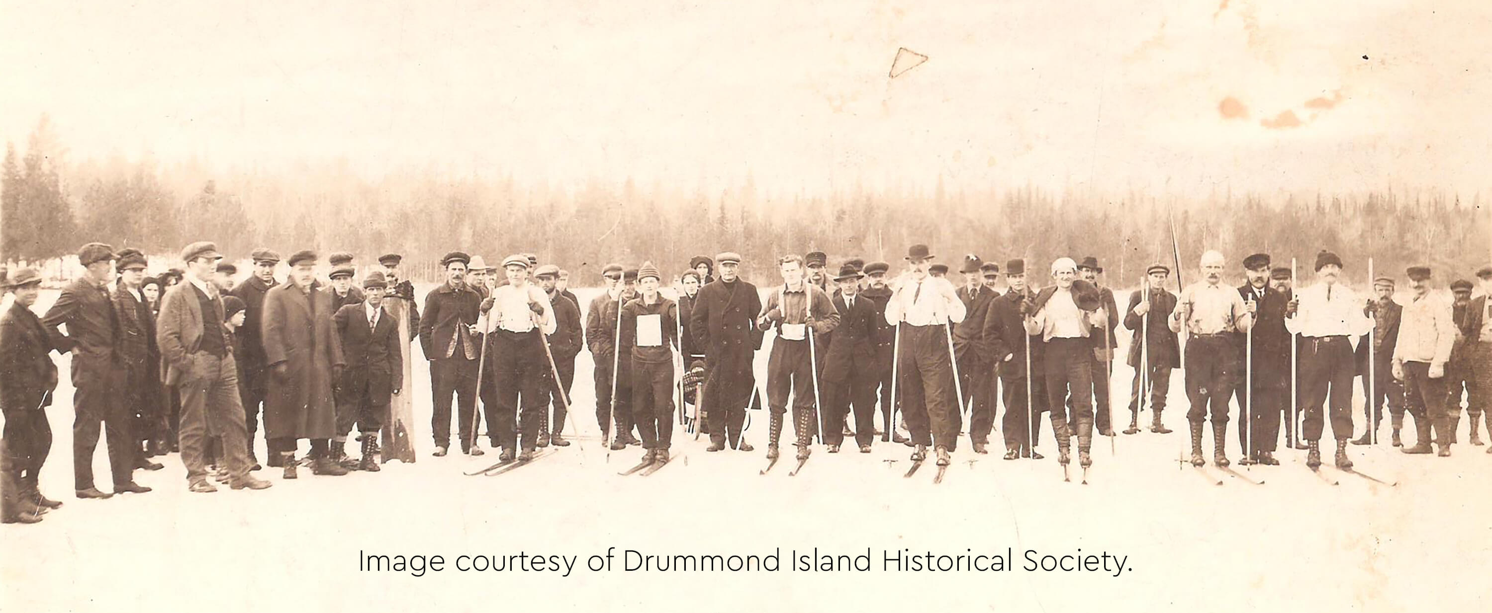 Historic image of participants in a ski race on the ice of Johnswood Bay.