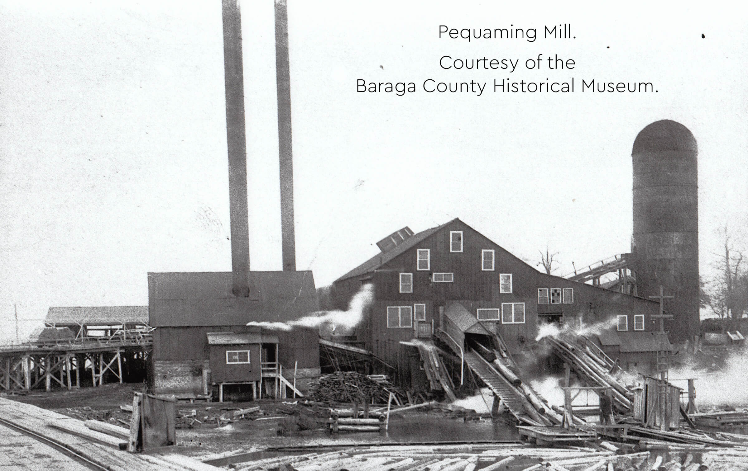 Historical image of Pequaming Mill with smokestacks and log conveyors
