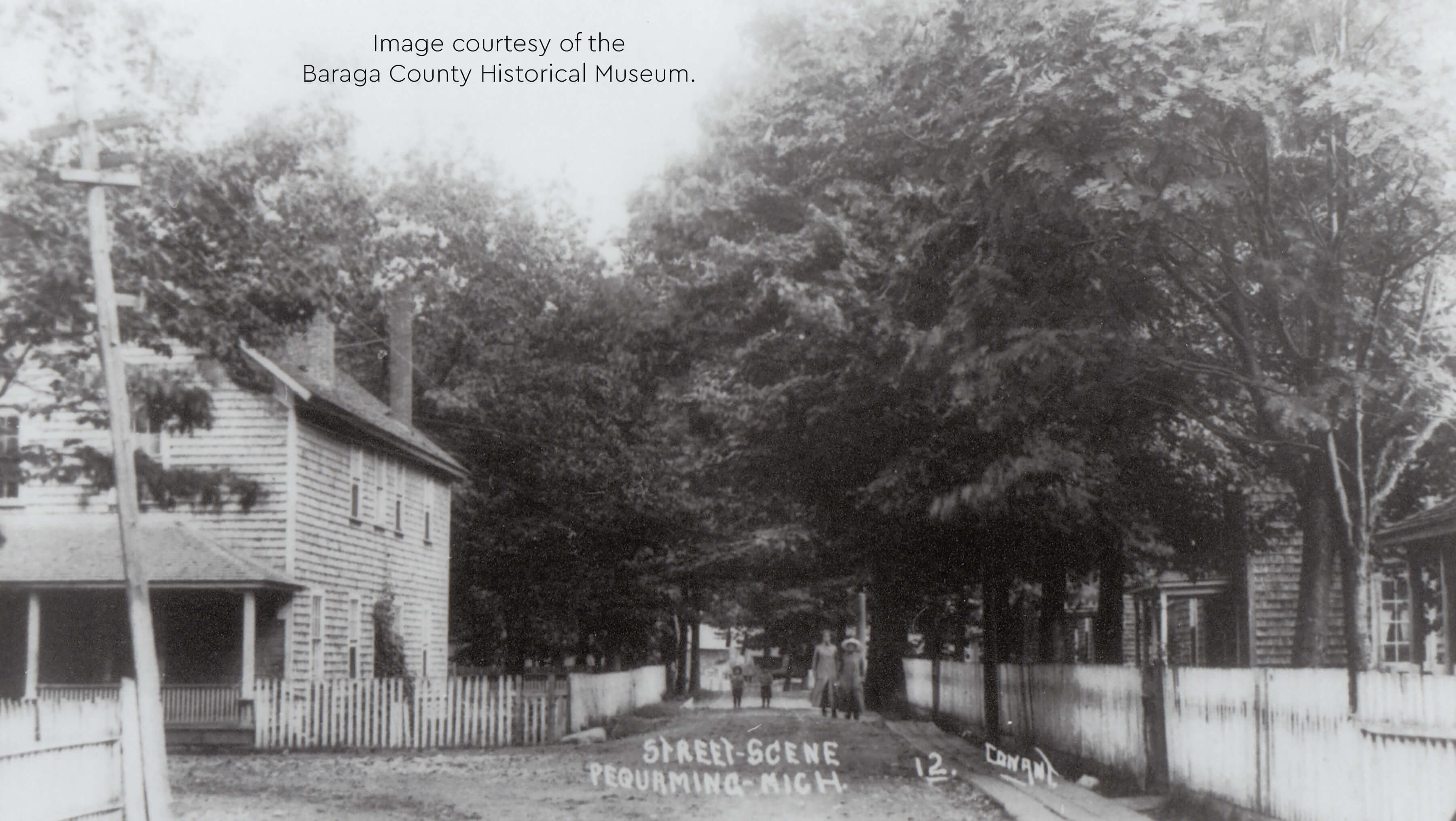 Historical street scene in Pequaming with wooden houses and fences