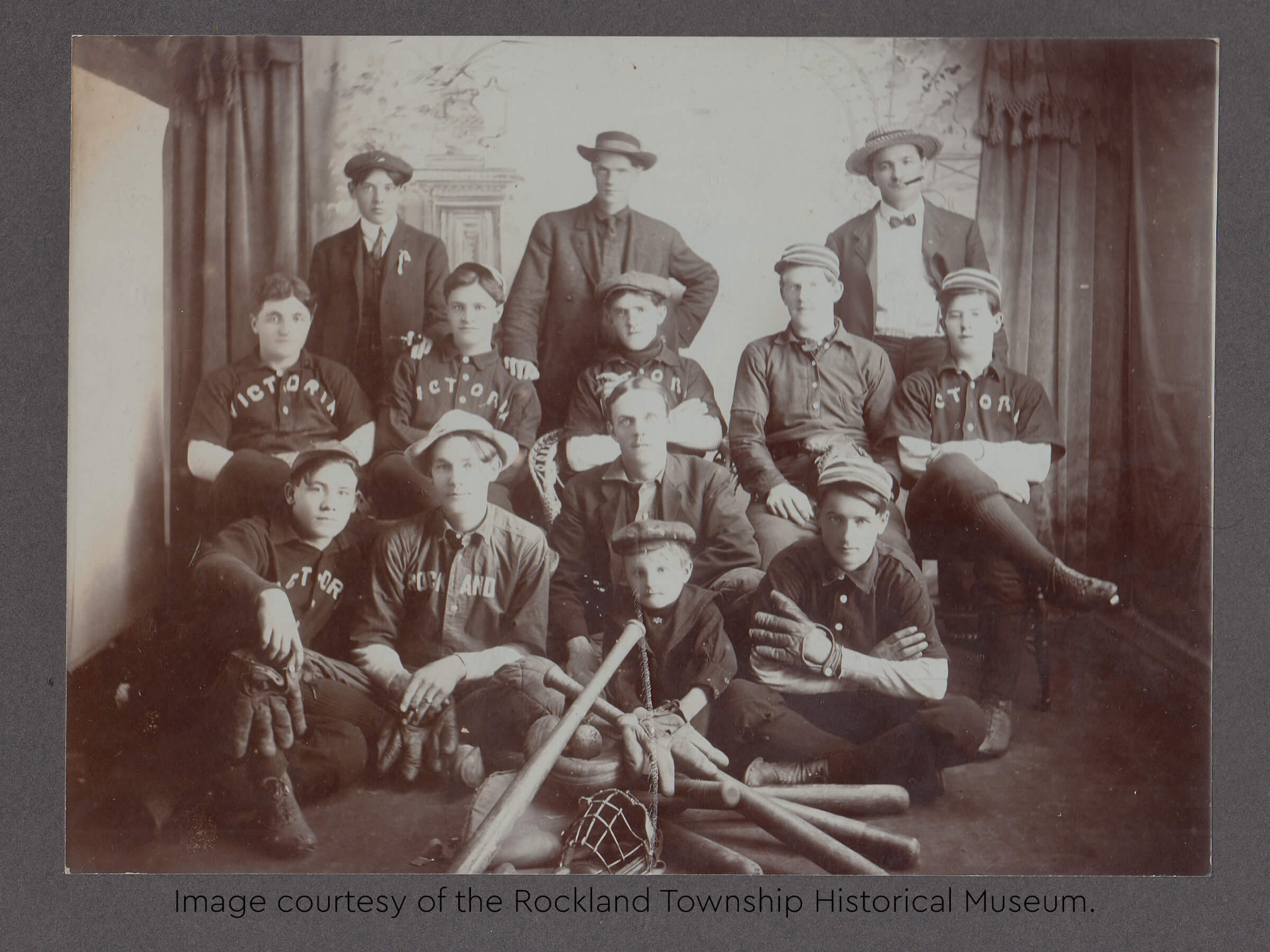 Historic photo of the Victoria baseball team posing with bats and gloves.