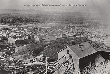 A historic photo showing Central Mine with mining buildings, houses, and piles of excavation debris.