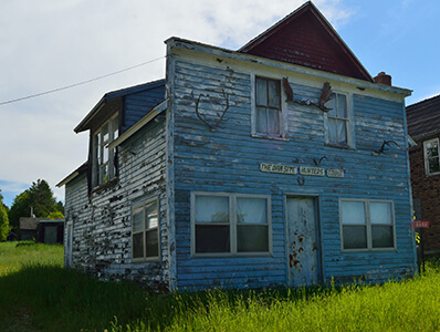 Abandoned building, The Dam Site Hunters Lodge, with peeling blue paint.