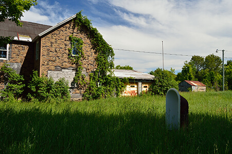 Abandoned brick building covered in vines in Dollarville.