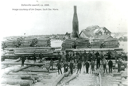 Historical photo of the Dollarville sawmill with workers and logs.