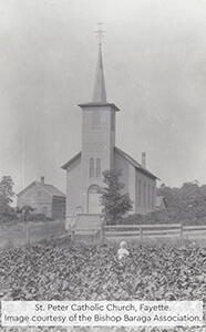 Historic photo of St. Peter Catholic Church with a child in a field.