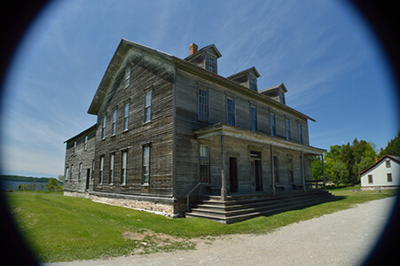 A large wooden hotel with a porch and weathered siding in Fayette State Park.
