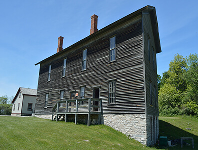 A two-story wooden building with stone foundation and chimneys in Fayette.