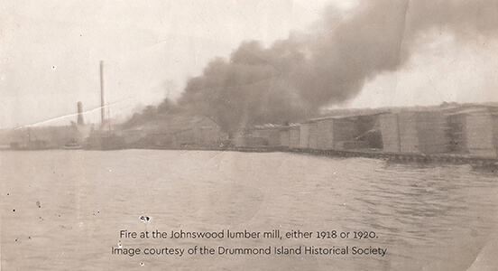 Historic image of fire at the Johnswood lumber mill with smoke billowing.