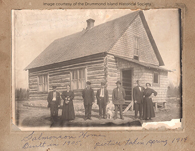 Historic image of the Salmonson family in front of their log house.