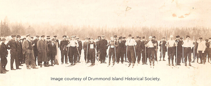Historic image of participants in a ski race on the ice of Johnswood Bay.