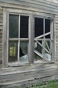 Detail of a broken window on an abandoned house in Labranche.
