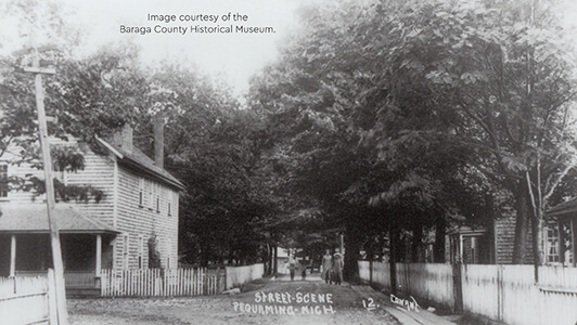 Historical street scene in Pequaming with wooden houses and fences