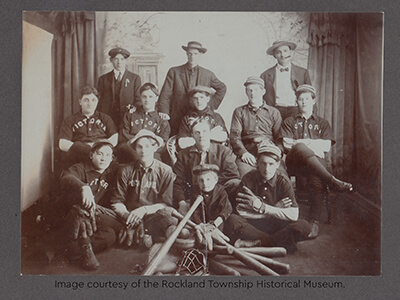 Historic photo of the Victoria baseball team posing with bats and gloves.