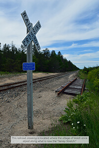 A railroad crossing sign near train tracks where Walsh once stood.