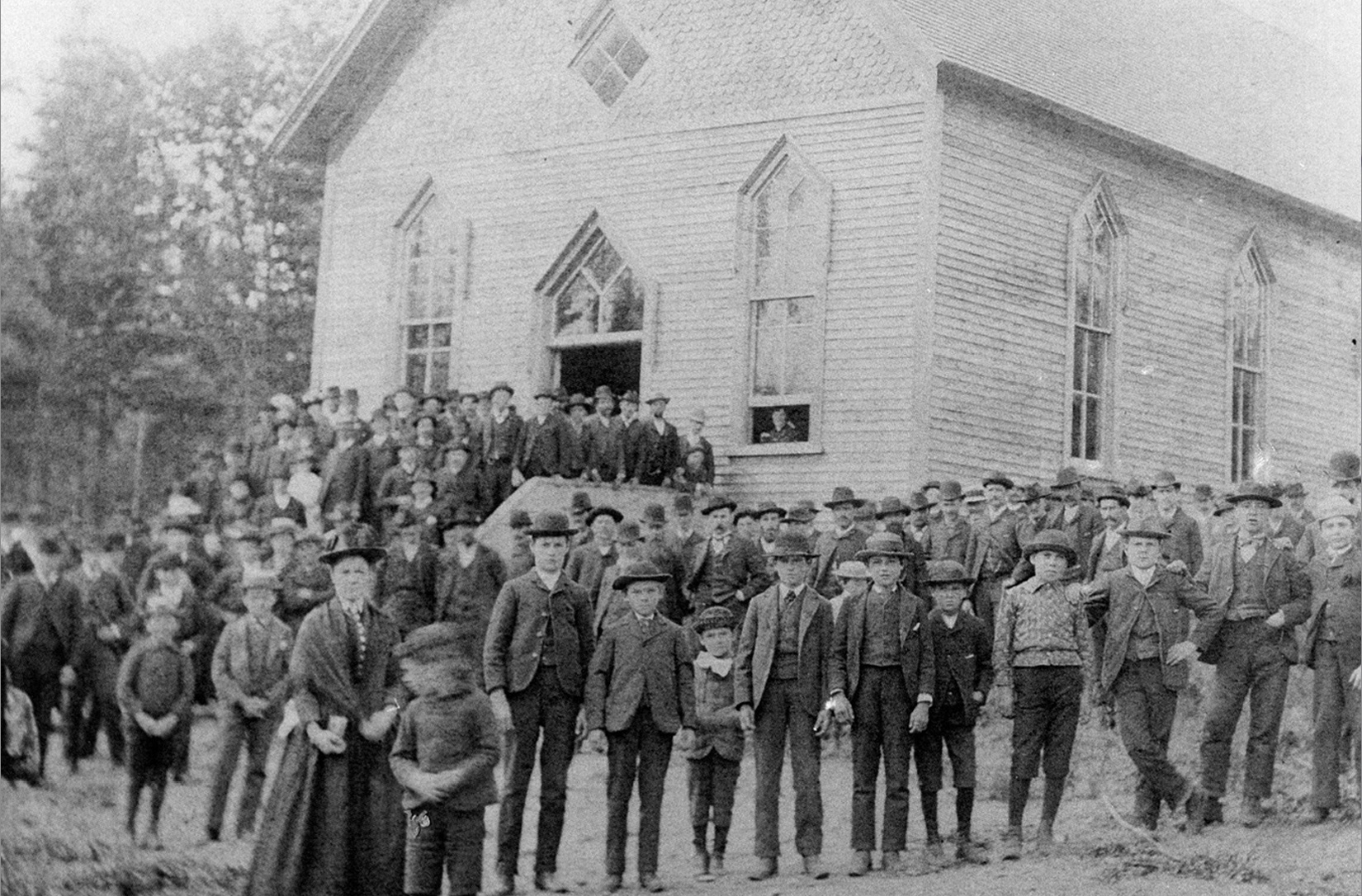 Large crowd gathers outside St. Anne Catholic Church in Chassell for a historic group photo.
