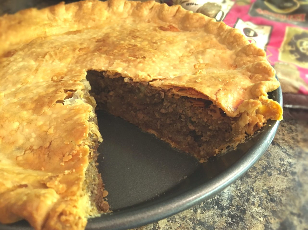 Goodreau family meat pie with single slice cut out.