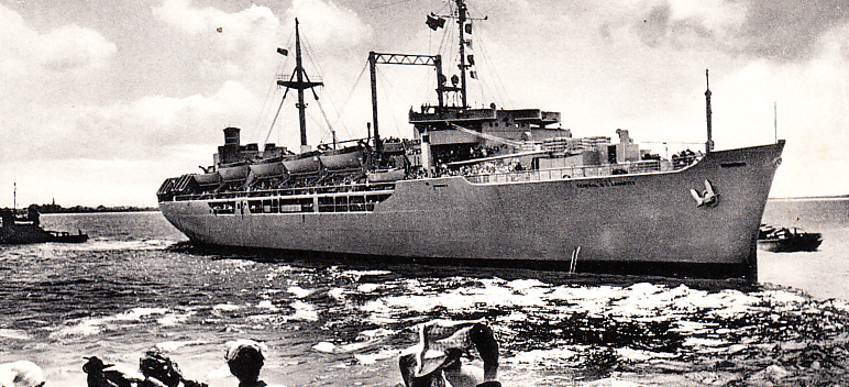 Crowd watches immigrant transport ship carrying displaced persons to the United States post-WWII.